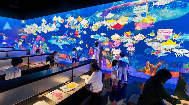 チームラボ、来場者が描いた魚たちが、東京・サンフランシスコ・上海など、世界中の展覧会を回遊する新たな体験を公開。他の都市で生まれた魚群を引き連れて戻ってくることも。