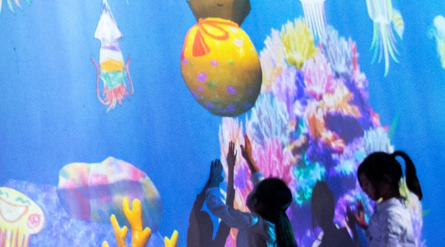 チームラボ、来場者が描いた魚たちが、東京・サンフランシスコ・上海など、世界中の展覧会を回遊する新たな体験を公開。他の都市で生まれた魚群を引き連れて戻ってくることも。