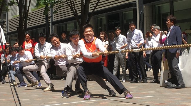 「大手町・丸の内・有楽町 仲通り綱引き大会」開催 大手町・丸の内・有楽町エリアでは、企業・就業者の健康づくり促進や交流を目的に、５月１３日（月）～１７日（金）の５日間